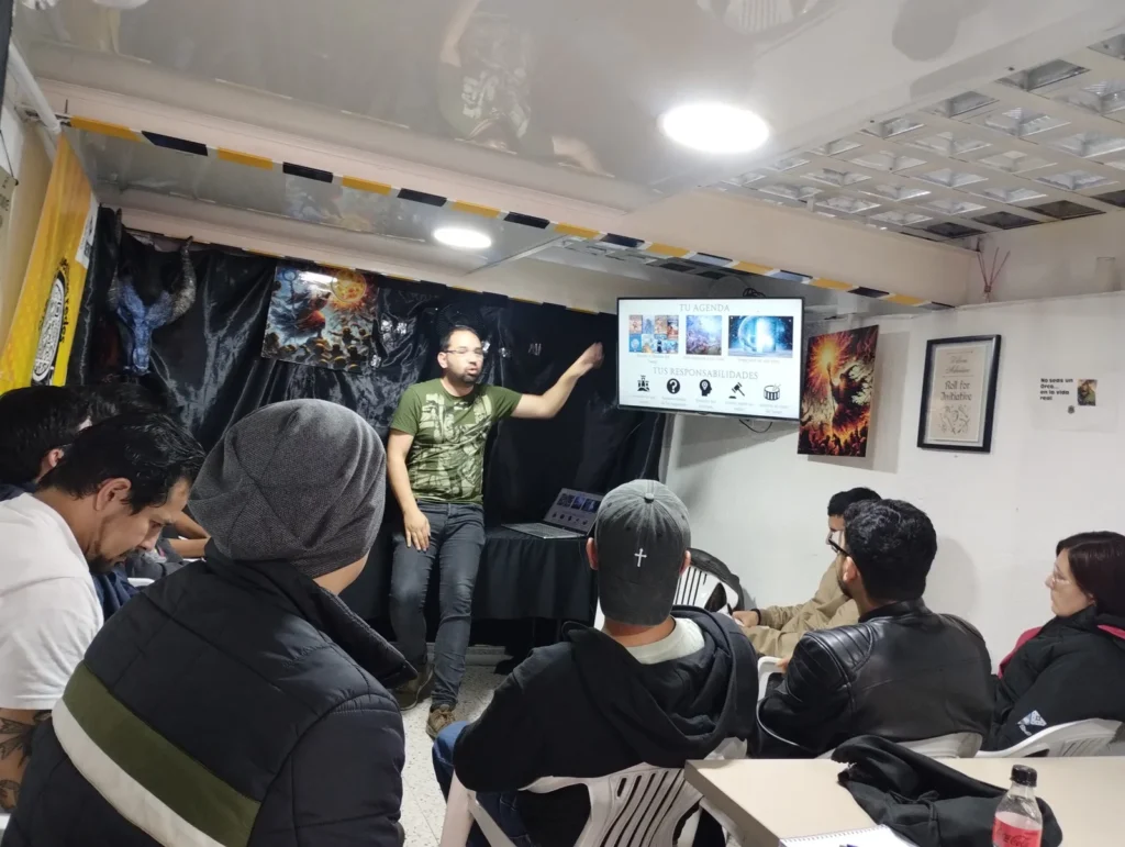 Wolf Kook dictando un taller frente a un grupo sentado, con una presentación proyectada