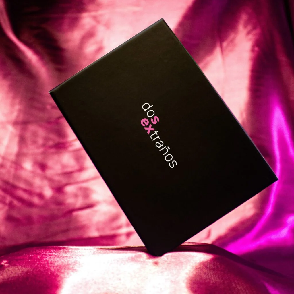 Caja negra del juego DoSEXtraños sobre una tela satinada fucsia