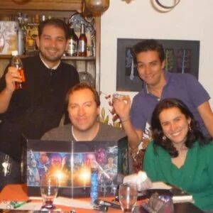 Cuatro personas jugando una partida de rol alrededor de una mesa con pantalla de máster